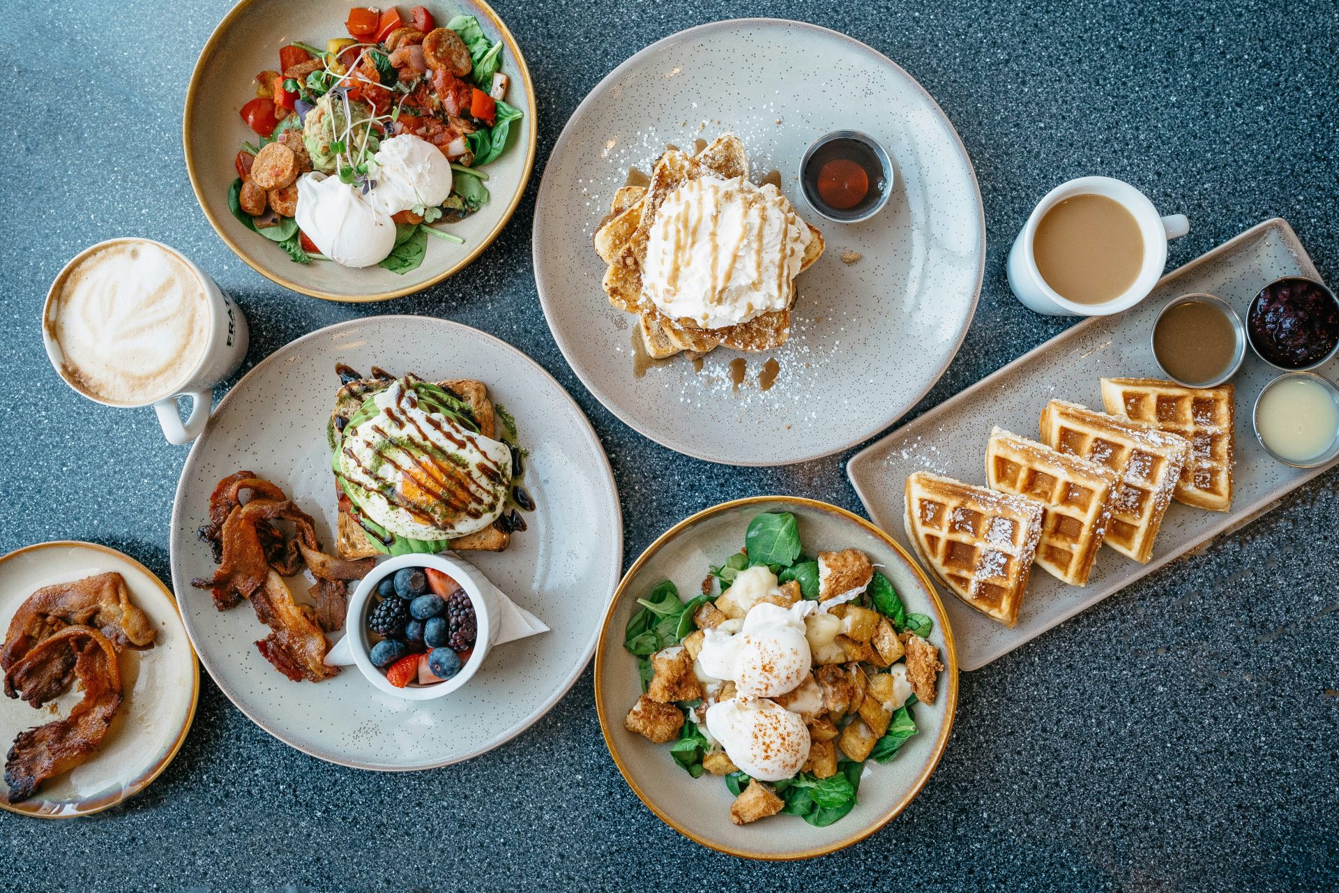 Loaded brunch table with waffles and coffee.